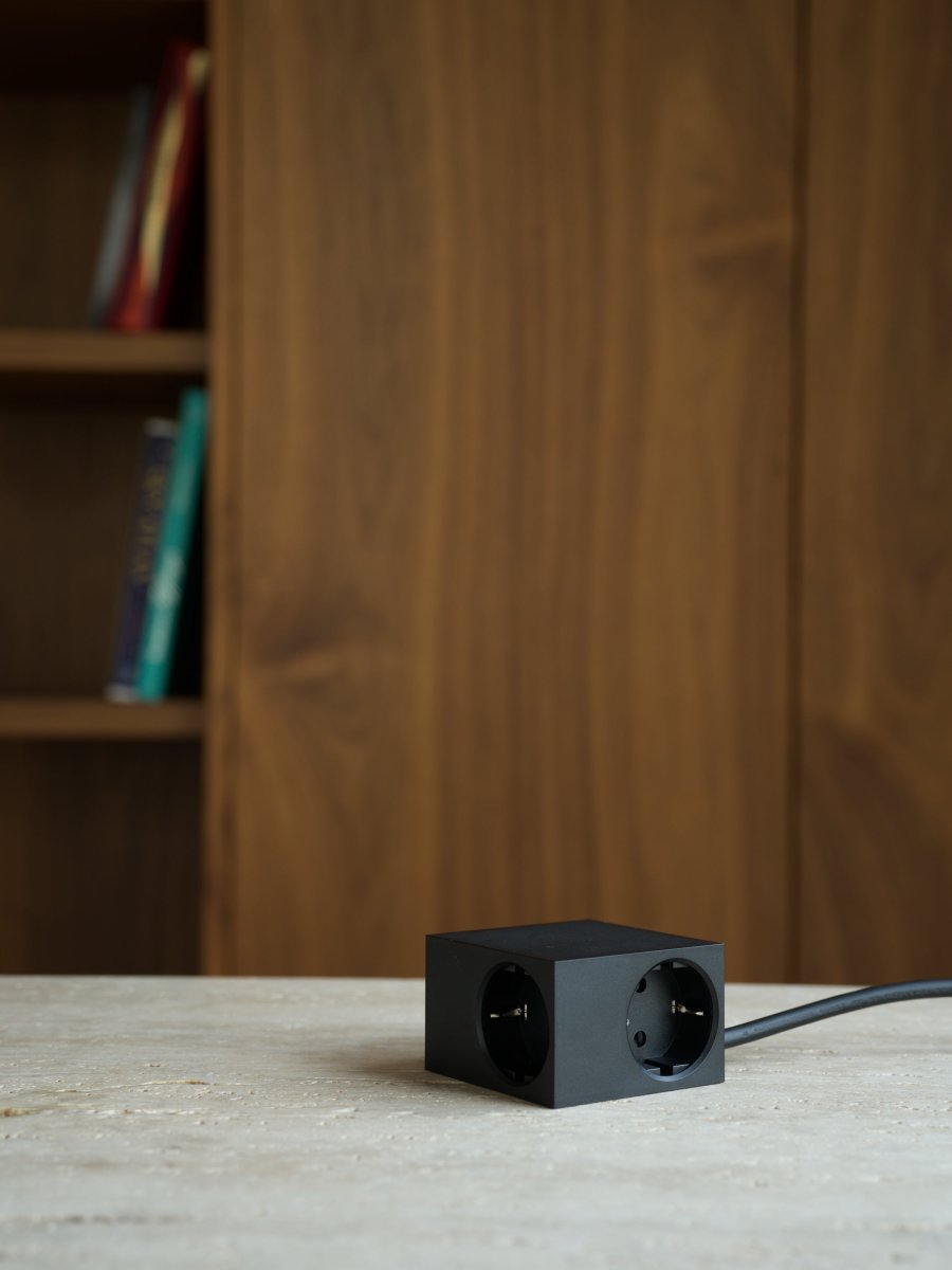 Cuboid Noir De Kord - Plusieurs options de montage&nbsp;: fixez la prise directement sur des surfaces m&eacute;talliques gr&acirc;ce aux c&ocirc;t&eacute;s magn&eacute;tiques, utilisez le support fourni avec surface de friction pour une fixation stable sur une table ou fixez-la au mur avec du ruban adh&eacute;sif 3M pour une prise de courant discr&egrave;te et facilement accessible.
