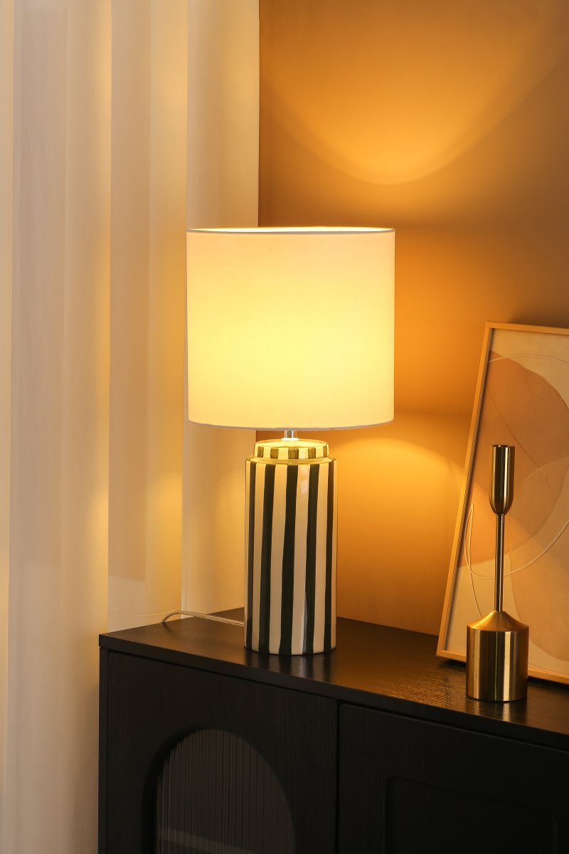 Faro 50cm Vert/blanc lampe de table De Nordic Lighting - Son pied en c&eacute;ramique, finition blanc cr&egrave;me et rayures vertes, cr&eacute;e un style &agrave; la fois dynamique et harmonieux.
