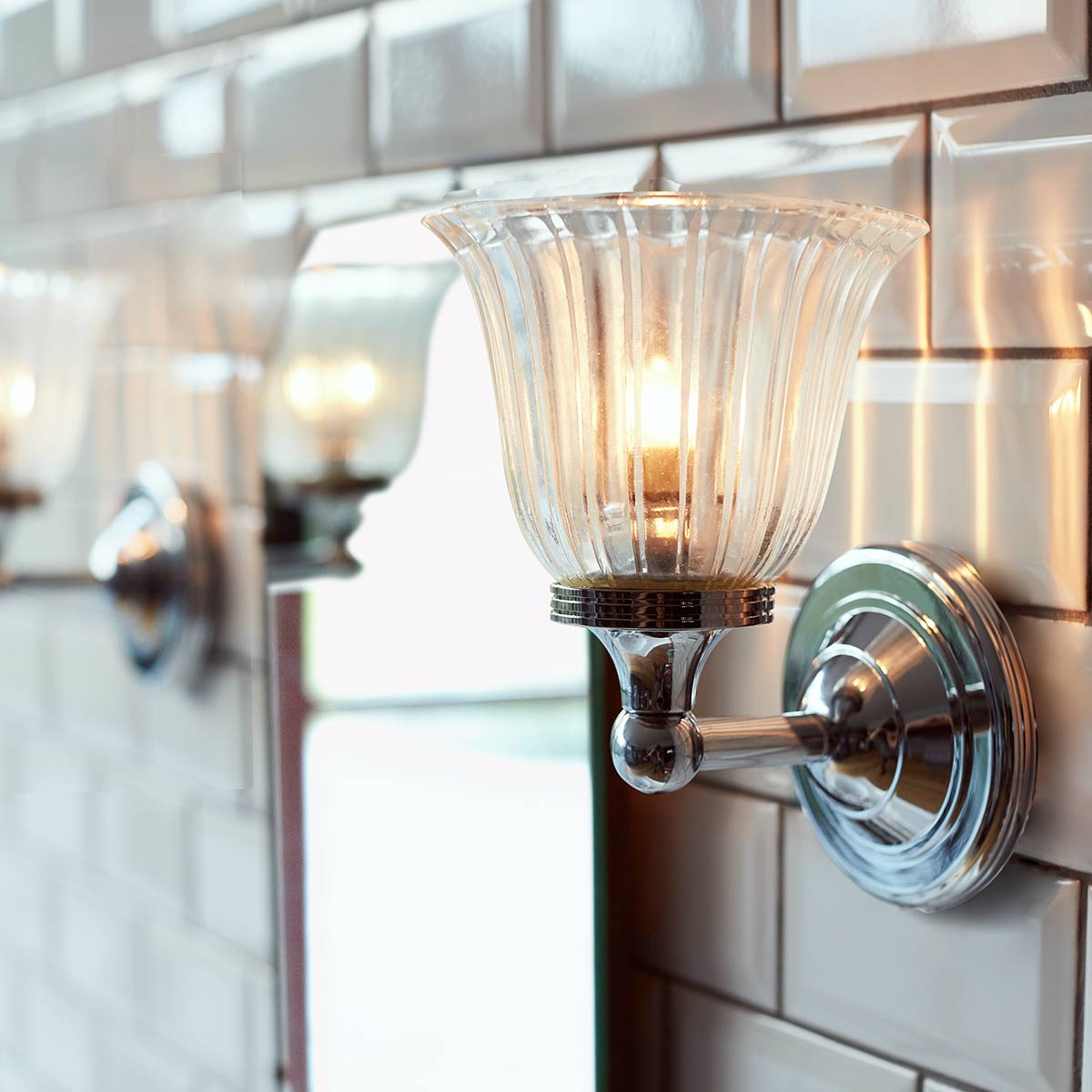 Austen Ø14 Chrome poli lampe de salle de bain De Elstead Lighting - La lampe a une finition chrom&eacute;e polie et un &eacute;l&eacute;gant abat-jour en verre, lui donnant un look intemporel.