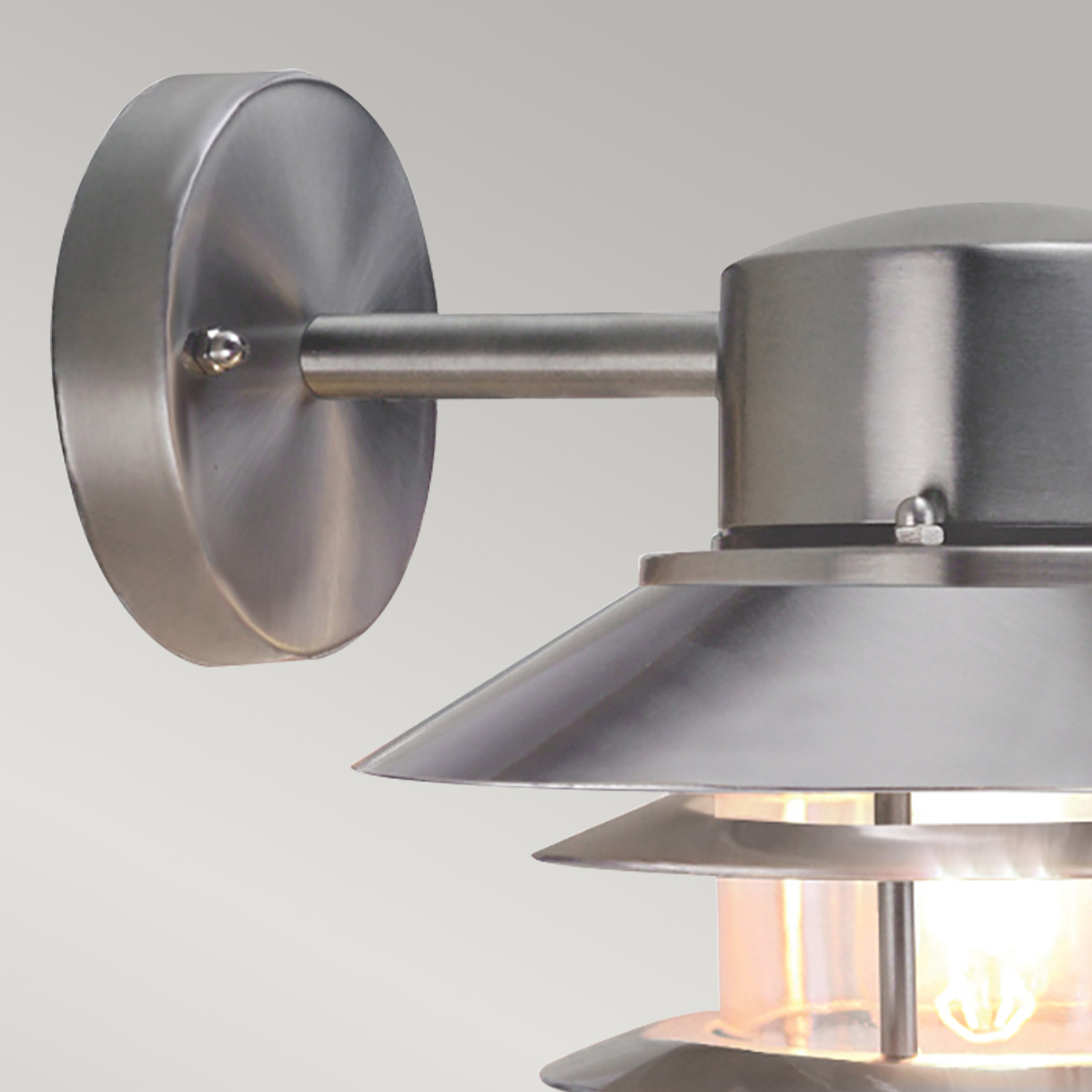 Copenhagen Ø22 Acier brossé lampe d’extérieur De Elstead Lighting - Tillverkad av rostfritt st&aring;l i borstad finish och glas, erbjuder den en h&aring;llbar och v&auml;dert&aring;lig konstruktion som passar perfekt f&ouml;r fasader, entr&eacute;er och uteplatser.