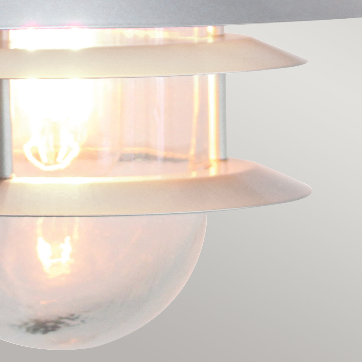 Copenhagen Ø22 Argent lampe d’extérieur De Elstead Lighting - Tillverkad av rostfritt st&aring;l i silverfinish och glas, erbjuder den en h&aring;llbar och v&auml;dert&aring;lig konstruktion som passar perfekt f&ouml;r fasader, entr&eacute;er och uteplatser.