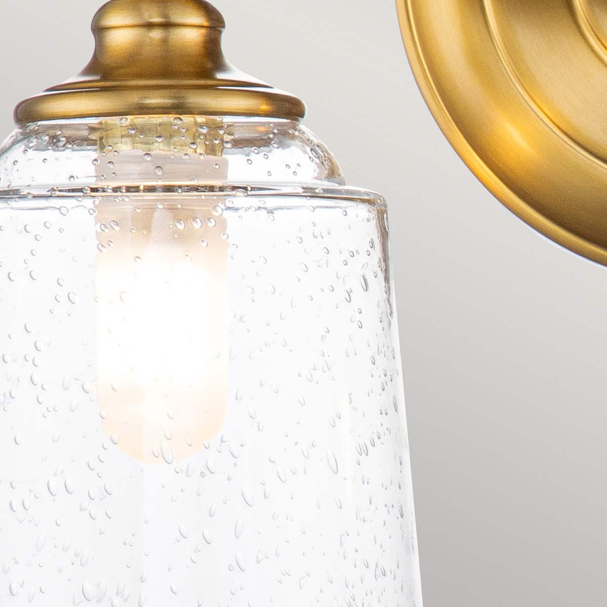 Huguenot Lake 33cm Laiton lampe de salle de bain De Elstead Lighting - Les élégants détails ronds et les cadres découpés à la main transmettent un sentiment d'artisanat traditionnel, tandis que le verre clair et texturé crée une lumière douce et invitante.