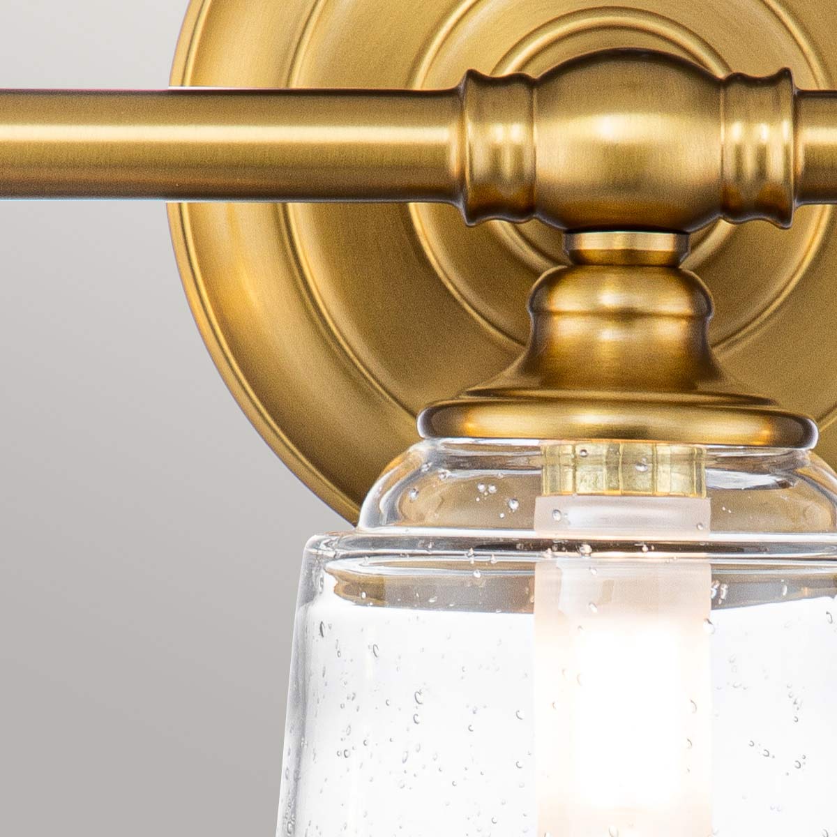 Huguenot Lake 53cm Laiton lampe de salle de bain De Elstead Lighting - Les élégants détails ronds et les cadres découpés à la main transmettent un sentiment d'artisanat traditionnel, tandis que le verre clair et texturé crée une lumière douce et invitante.