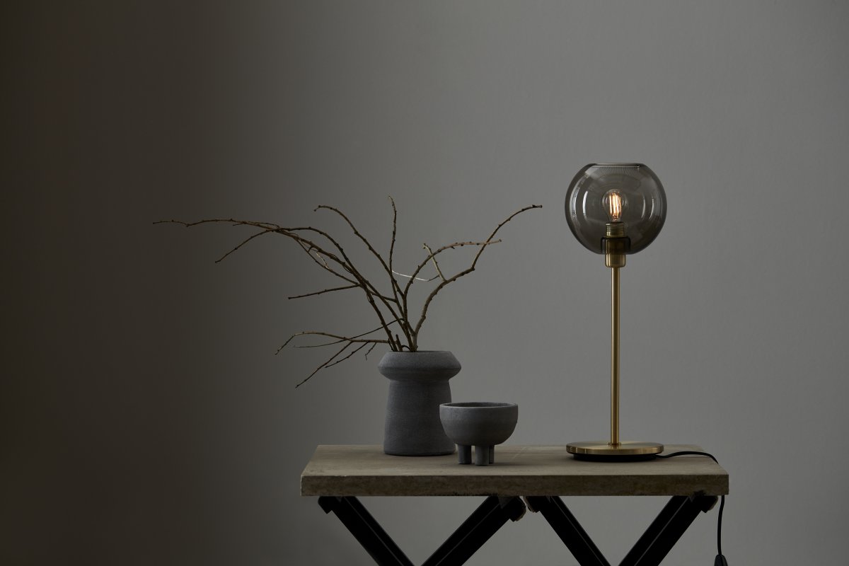 Gloria 46cm Laiton/fumée lampe de table De Belid - Gloria a un design simple et &eacute;l&eacute;gant avec une base de lampe en m&eacute;tal et un abat-jour rond en verre.