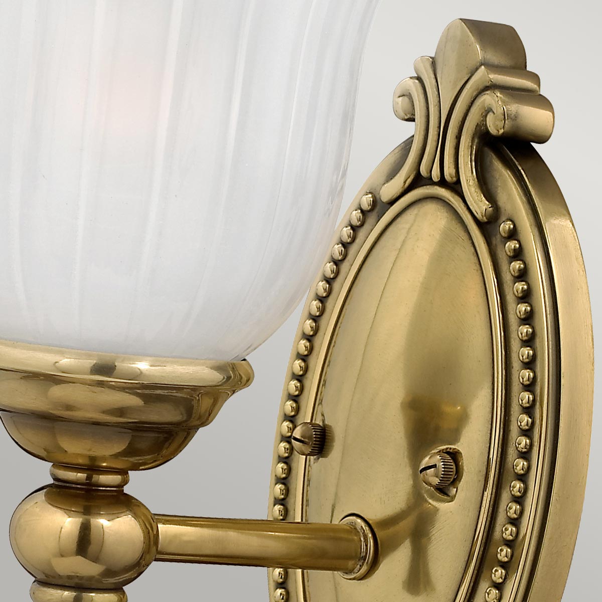 Francoise Ø15 Laiton lampe de salle de bain De Elstead Lighting - Il est doté d'un magnifique abat-jour en verre dépoli avec un design nervuré qui projette une lumière douce, et la base décorative en laiton ajoute une touche élégante.
