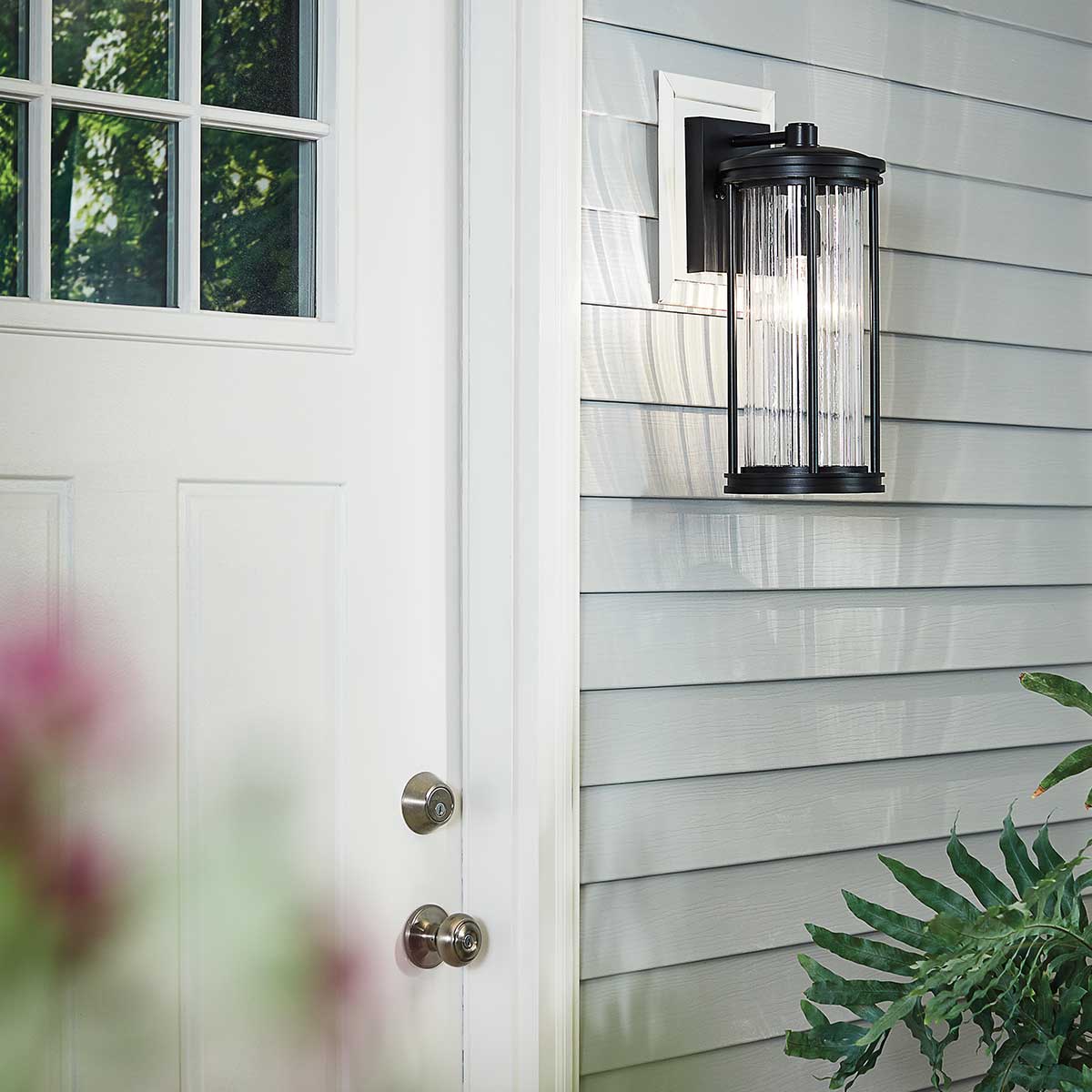 Barras Noir lampe d’extérieur De Elstead Lighting - L'applique murale Barras a un design classique avec une finition noire et un verre transparent et nervuré, inspiré du début de l'ère électrique.