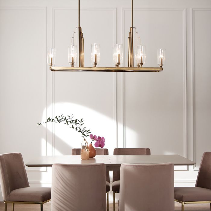 Kimrose 114cm Laiton brossé suspension De Elstead Lighting - Les abat-jour cylindriques en verre sont transparents et présentent des rainures verticales, créant un effet d'éclairage unique et subtil.