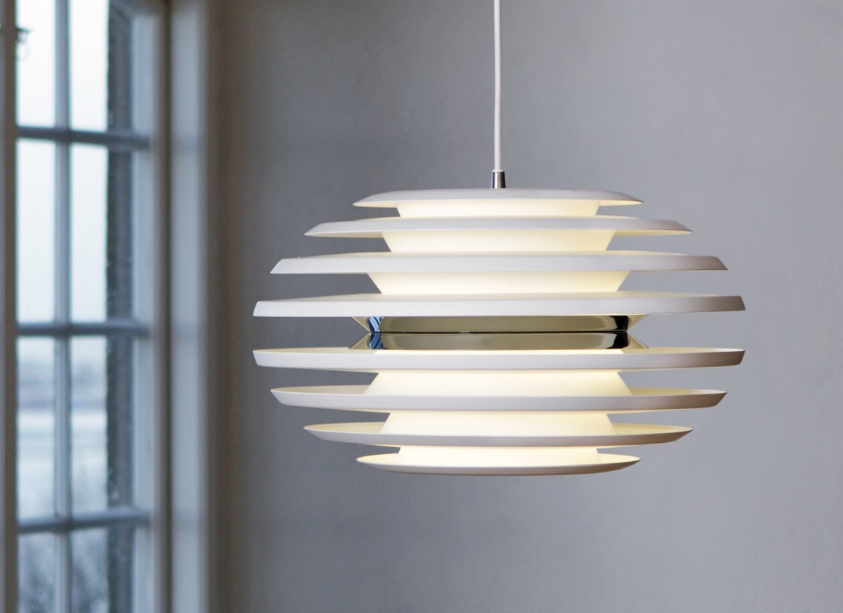 Ellipse Ø50 Blanc/chrome suspension De Belid - Son abat-jour elliptique en m&eacute;tal cr&eacute;e un flux lumineux doux et captivant qui se diffuse harmonieusement dans la pi&egrave;ce, tandis que la lumi&egrave;re semble presque lourde dans l'air.